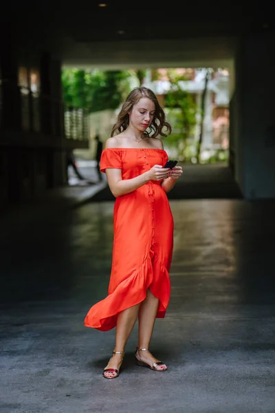 Симпатичная брюнетка снимает оранжевое платье